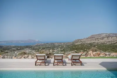 a group of chairs sitting next to a swimming pool at JK's 4 in Vamos