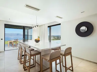 a dining room with a large table and chairs at Rastoni Villa I ''Free'' heated pool & panoramic view in Kalivianí