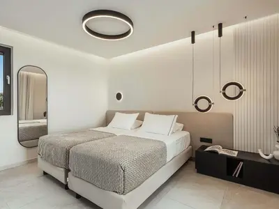 a bedroom with a large bed and a mirror at Rastoni Villa I ''Free'' heated pool & panoramic view in Kalivianí