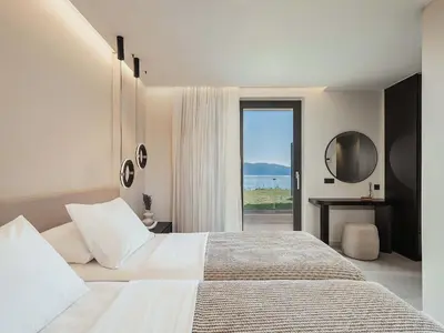 a bedroom with a bed with a view of the ocean at Rastoni Villa I ''Free'' heated pool & panoramic view in Kalivianí