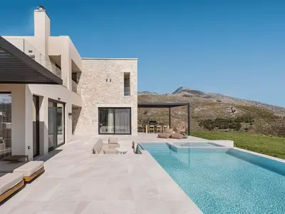 a house with a swimming pool next to a house at Rastoni Villa I ''Free'' heated pool & panoramic view in Kalivianí