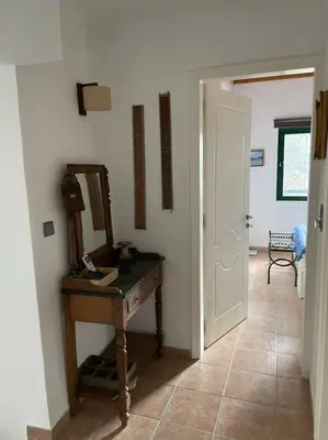 a hallway with a table and a mirror and a door at Perfect home away from home in Palio Gerani