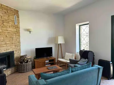 a living room with two blue chairs and a television at Perfect home away from home in Palio Gerani