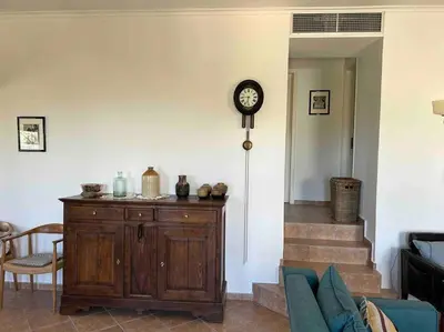 a living room with a clock on a wall at Perfect home away from home in Palio Gerani