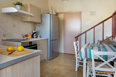 a kitchen with a refrigerator and a table with fruit on the counter at Avra Apartments in Kalyves