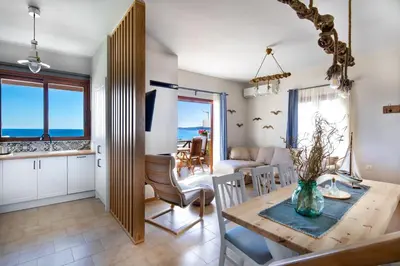 a kitchen and living room with a table and chairs at Avra Apartments in Kalyves