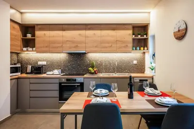 a kitchen with a table with two glasses of wine at Erato - Newly renovated Home with Parking in Chania Town