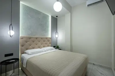 a bedroom with a large bed and two lights at Hypnos Luxury Lodgings in Chania Town