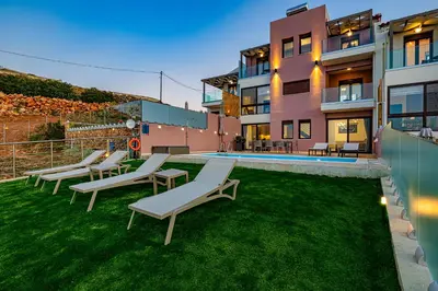 a group of lounge chairs on a lawn in front of a building at Villa Mari mini in Kondópoula
