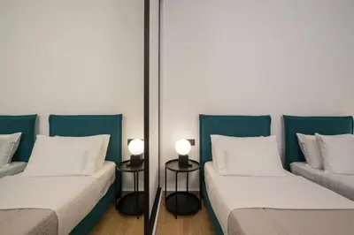 two beds in a room with two lamps at Be Crete - White Pearl in Chania Town