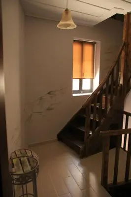 a room with a staircase with a window and a chair at Elia Portou Rooms in Chania Town
