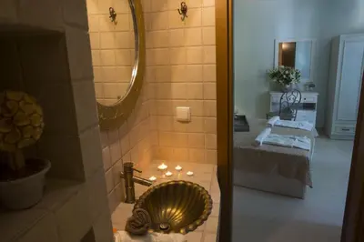 a bathroom with a gold sink and a mirror at Elia Portou Rooms in Chania Town