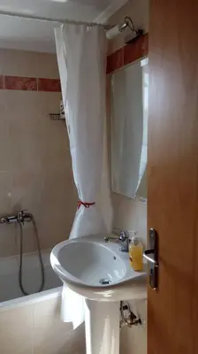 a bathroom with a sink and a shower curtain at COSY NEW APARTMENT- 5' to the beach, 15' to center in Chania Town