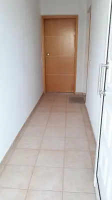 a hallway with a door and a tiled floor at COSY NEW APARTMENT- 5' to the beach, 15' to center in Chania Town