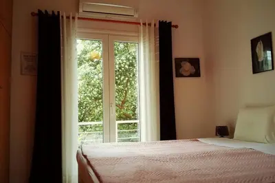 a bedroom with a bed and a large window at QUIET NEW Apartment-5' to the beach, 15' to center in Chania Town