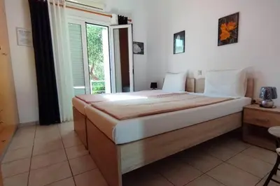 a bedroom with a large bed and a window at QUIET NEW Apartment-5' to the beach, 15' to center in Chania Town