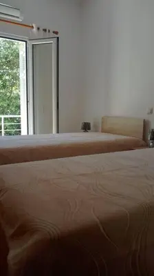 two beds in a room with a window at QUIET NEW Apartment-5' to the beach, 15' to center in Chania Town