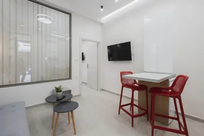 a living room with a table and two red chairs at Peris 4 with Yard steps to Old Town - AC, Wifi in Chania Town