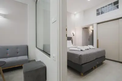 a bedroom with a bed and a chair and a mirror at Peris 4 with Yard steps to Old Town - AC, Wifi in Chania Town