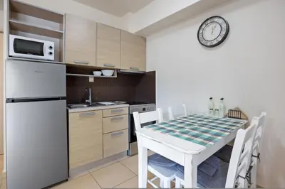 a kitchen with a white table and a white refrigerator at Dimi's Studio Center in Chania in Chania Town