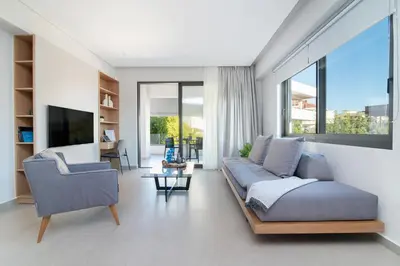 a living room with a couch and two chairs at A3stays a cozy vacation retreat in Chania Town