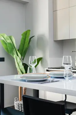 a white table with two wine glasses and a plant at A3stays a cozy vacation retreat in Chania Town