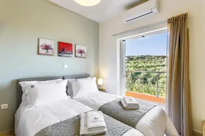 a bedroom with a bed and a large window at Cyan Icons Villas Kalyves Chania in Kalyves