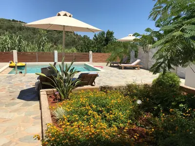 a patio with an umbrella and a swimming pool at Cyan Icons Villas Kalyves Chania in Kalyves