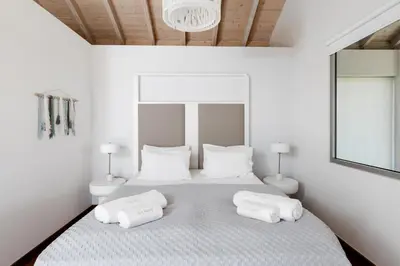 a bedroom with a white bed with two white pillows at Villa Shell in Tersanas