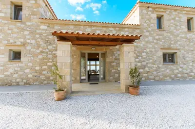 a stone building with a door and two potted plants at Villa Kalithea in Kissamos