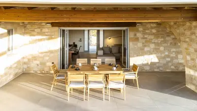 a dining room with a wooden table and chairs at Villa Kalithea in Kissamos