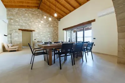 a dining room with a wooden table and chairs at Villa Kalithea in Kissamos