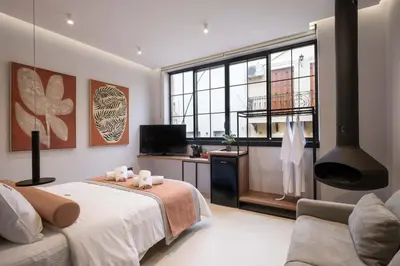 a bedroom with a bed and a tv and a couch at Citrus Daliani Rooms in Chania Town