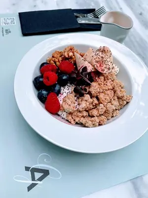 a plate of cereal and fruit on a table at Citrus Daliani Rooms in Chania Town