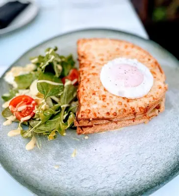 a plate with a sandwich and a salad on it at Citrus Daliani Rooms in Chania Town