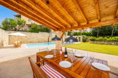 a wooden table with wine glasses on a patio at Villa Nafsika in Vamos