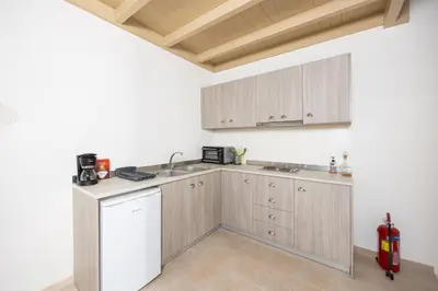 a kitchen with white walls and wooden cabinets at Villa Nafsika in Vamos