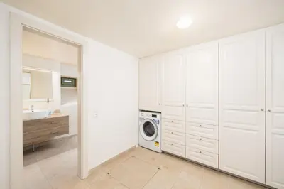 a bathroom with white cabinets and a washing machine at Villa Nafsika in Vamos