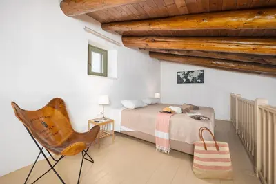 a bedroom with a bed and a chair in it at Villa Nafsika in Vamos