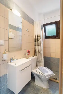 a bathroom with a toilet and a sink and a mirror at Almyrida Bay View House III BY APOKORONAS-VILLAS in Almirida