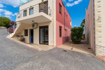 a pink and white building on a street at Almyrida Bay View House III BY APOKORONAS-VILLAS in Almirida