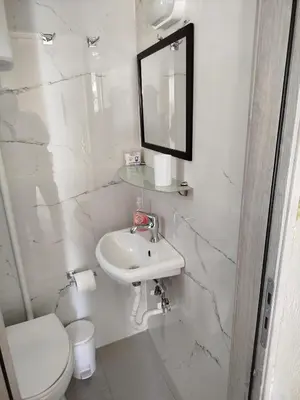 a white bathroom with a sink and a toilet at Stefanos Garden3 in Arménoi