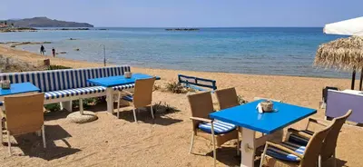 two tables and chairs on a beach with the ocean at Sky & Sea 3 in Kato Daratso