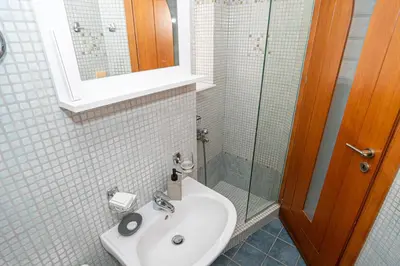 a bathroom with a sink and a glass shower at CityNest apartment in Chania Town