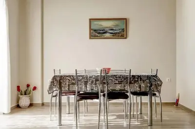 a dining room table with chairs and a picture on the wall at Kleio Studios in Ravdhoúkha