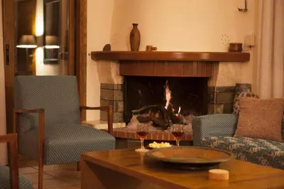 a living room with two chairs and a fireplace at Aori Hillside Villa in Kántanos