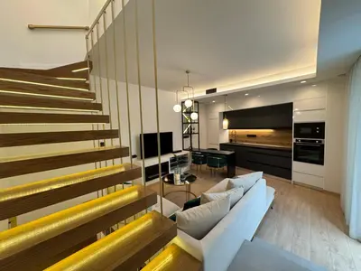 a living room with a couch and a staircase at Ethyr Atrium in Chania Town