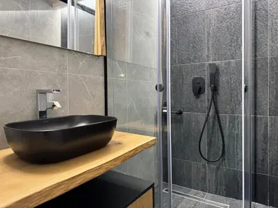 a bathroom with a black sink and a shower at Ethyr Atrium in Chania Town