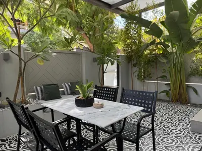 a patio with a table and chairs and plants at Ethyr Atrium in Chania Town