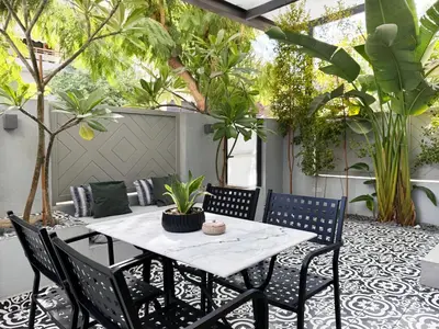 a table and chairs on a patio with plants at Ethyr Atrium in Chania Town
